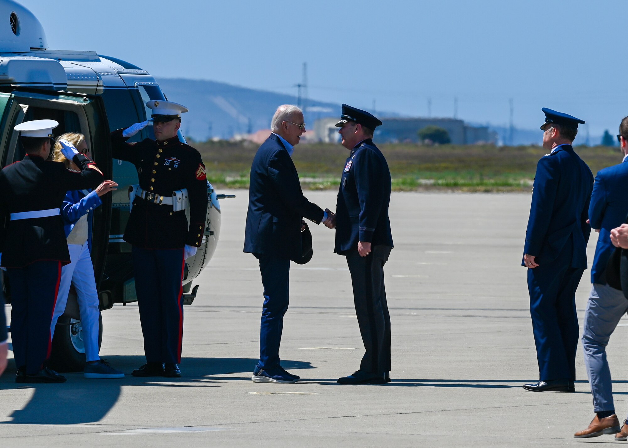President Biden greets a man in uniform.