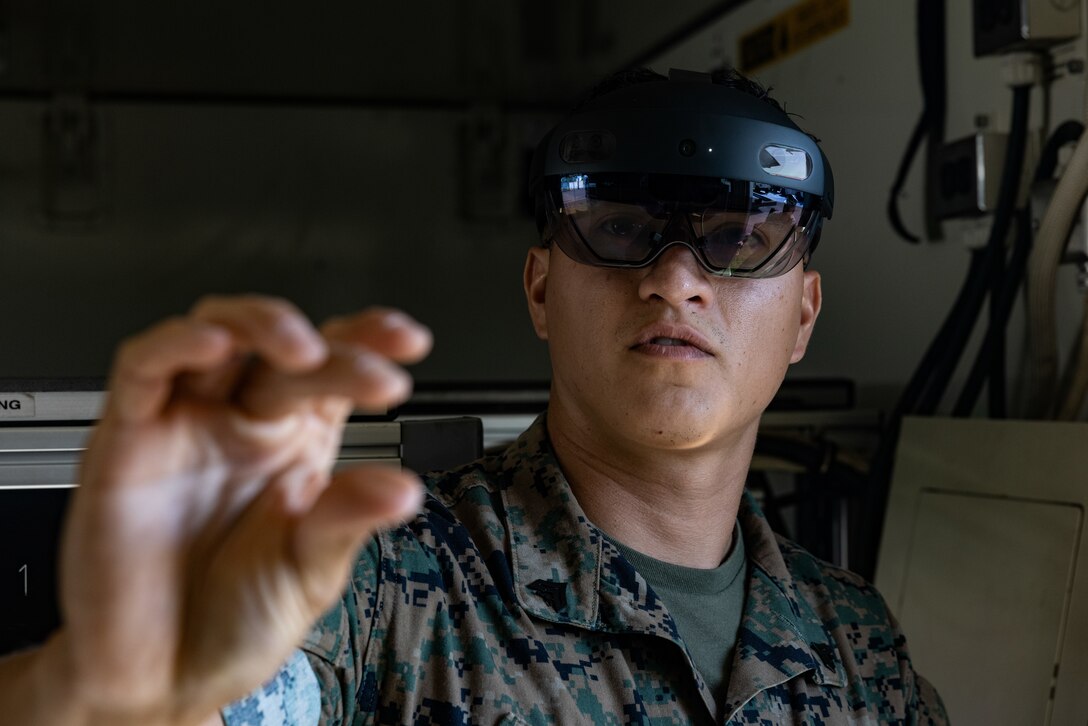 U.S. Marine Corps Cpl. Vradley Cerna, from Texas, a digital wideband systems maintainer with Marine Wing Communications Squadron (MWCS) 28, tests tele-maintenance capabilities at Marine Corps Air Station Cherry Point, North Carolina, Aug. 21, 2024. Marine Depot Maintenance Command is experimenting with augmented reality technology as part of its effort to modernize its maintenance capabilities from industrial-era practices to technologies suitable and capable of meeting the demands of the Information Age. (U.S. Marine Corps photo by Lance Cpl. Orlanys Diaz Figueroa)