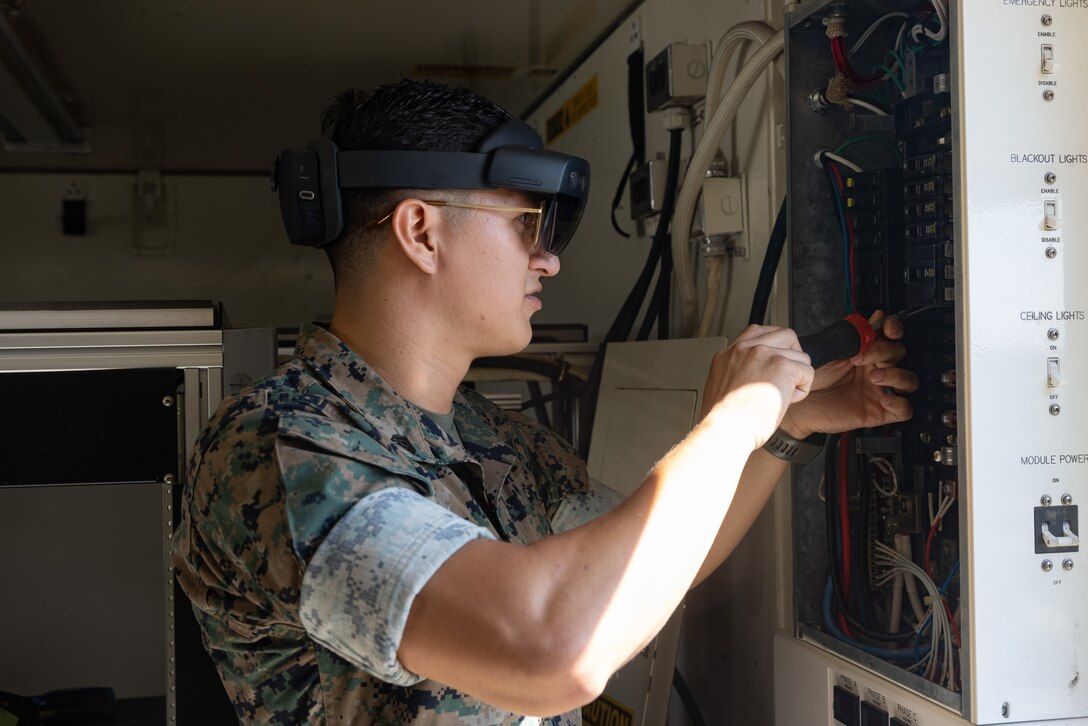 U.S. Marine Corps Cpl. Vradley Cerna, from Texas, a digital wideband systems maintainer with Marine Wing Communications Squadron (MWCS) 28, tests tele-maintenance capabilities at Marine Corps Air Station Cherry Point, North Carolina, Aug. 21, 2024. Marine Depot Maintenance Command is experimenting with augmented reality technology as part of its effort to modernize its maintenance capabilities from industrial-era practices to technologies suitable and capable of meeting the demands of the Information Age. (U.S. Marine Corps photo by Lance Cpl. Orlanys Diaz Figueroa)