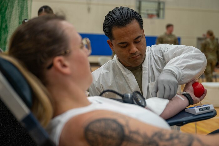 Medic prepares donor for blood donation.