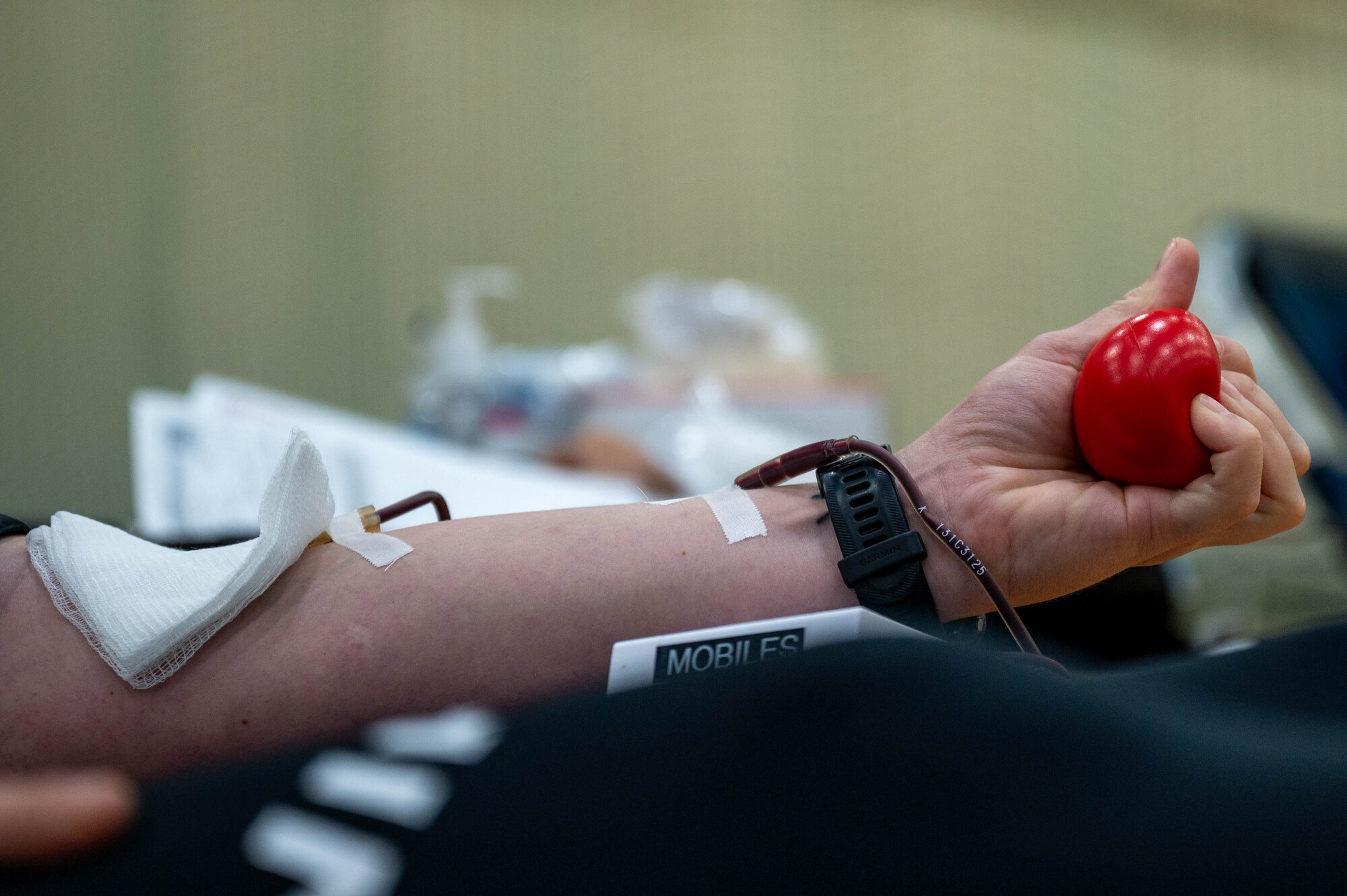 Blood donor squeezes stress ball.