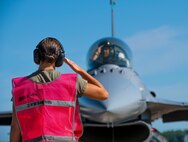 U.S. Air Force Tech Sgt. Erin Luke, a weapons specialist assigned to the Ohio National Guard’s 180th Fighter Wing, salutes an F-16 pilot before takeoff during exercise Northern Lightning at Volk Field, Camp Douglas, Wis., Aug. 7, 2024.