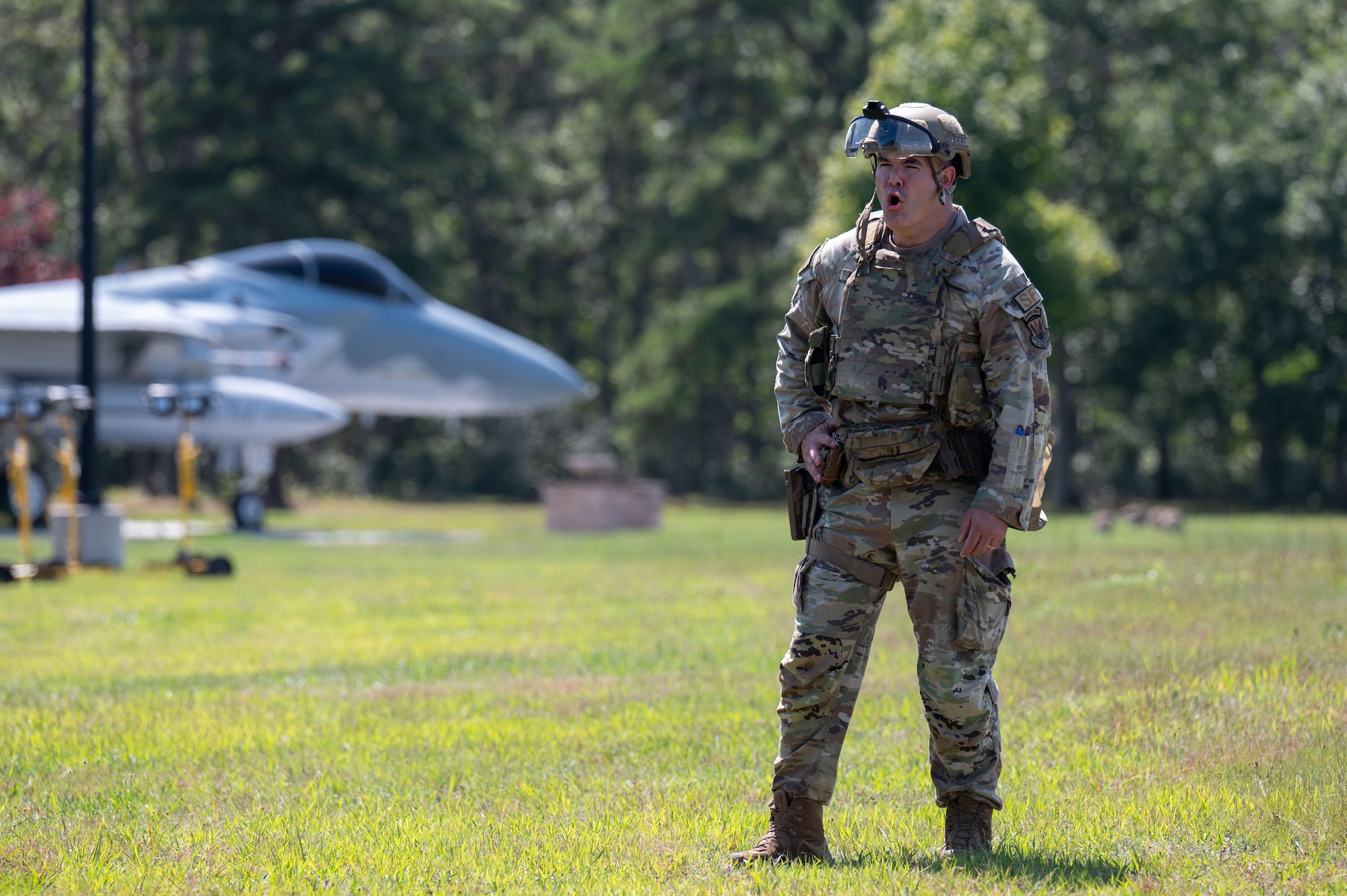 Airmen and Soldiers stand in a formation with helmets, shields and other protective gear