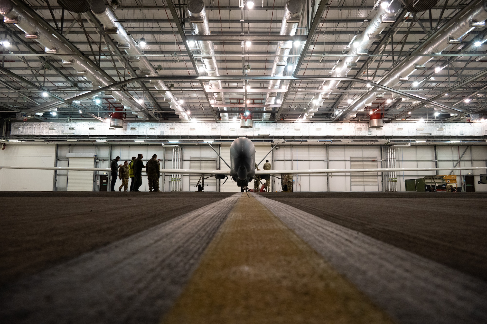 An RQ-4B Global Hawk assigned to Grand Forks Air Force Base’s 319th Reconnaissance Wing is inspected by Airmen.