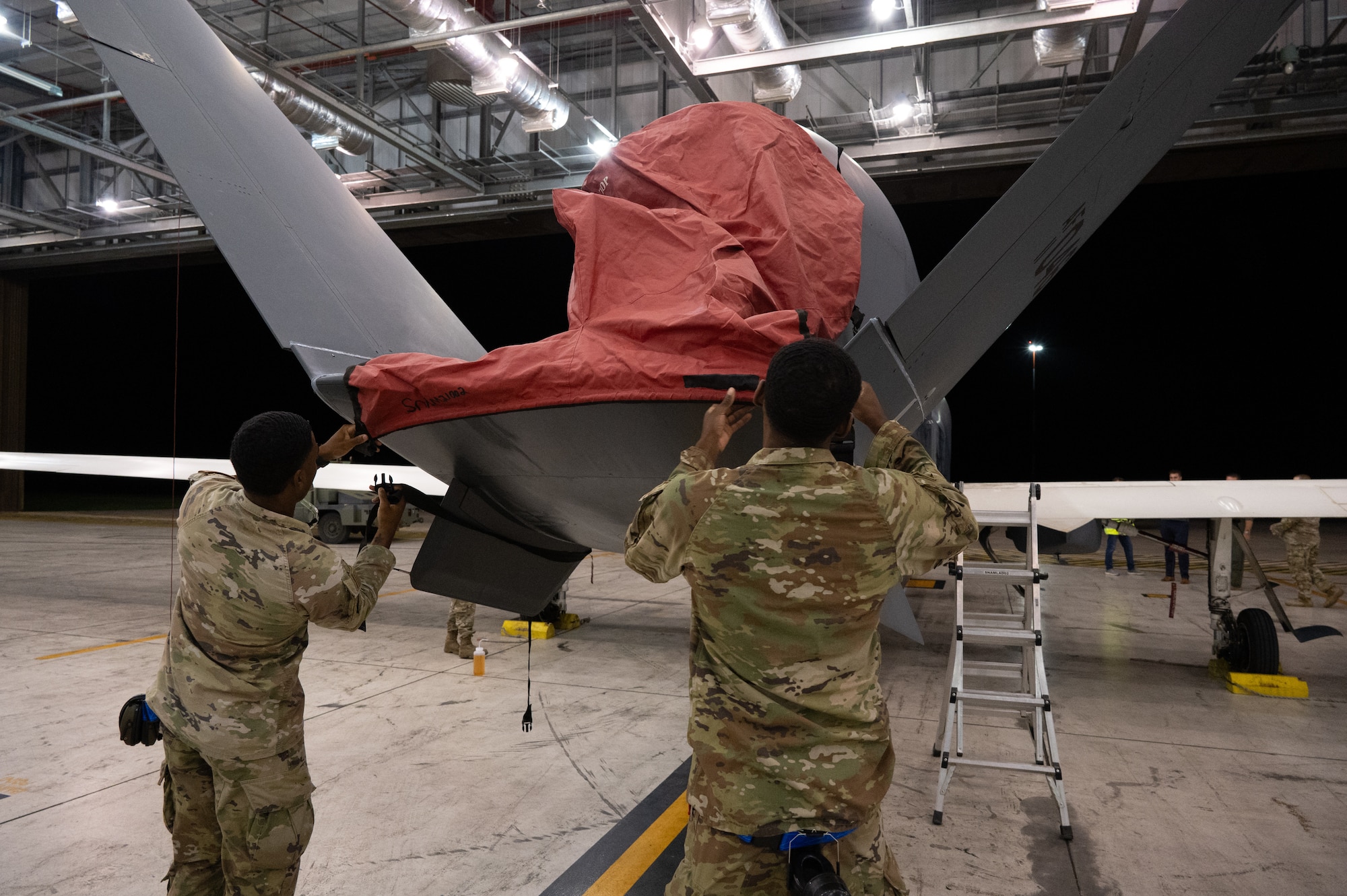 Airmen apply aircraft covers.