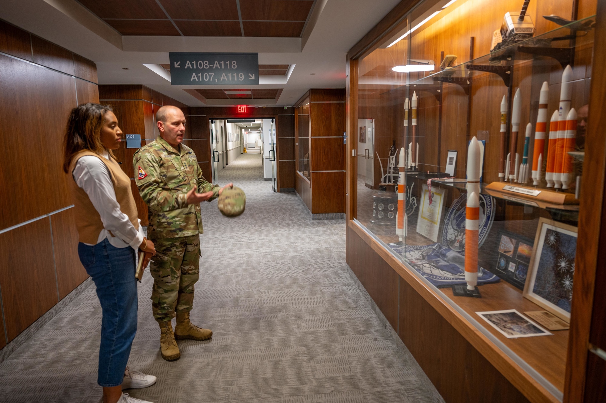 Senior military member and congressional staff review historical military artifacts.