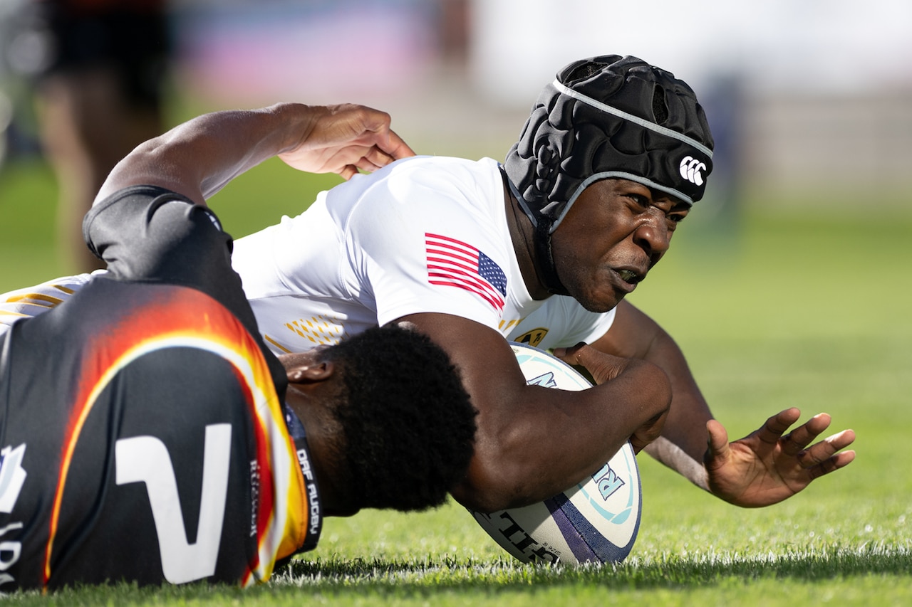 An athlete falls to the grass.