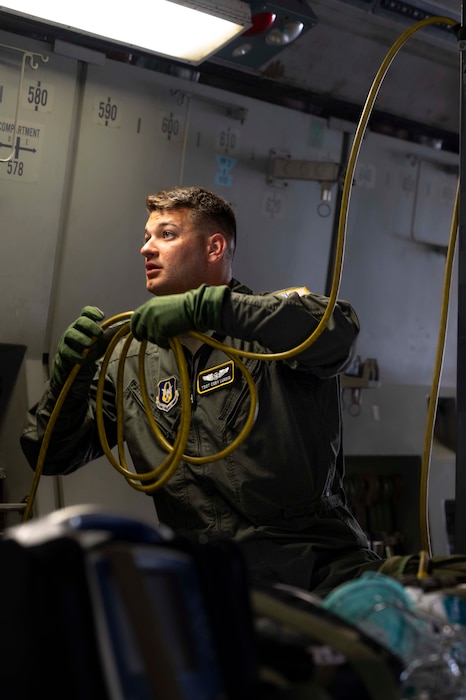 a portrait photo of a U.S. Airman in a C-17. He is providing aeromedical evacuation support by hooking up medical equipment.