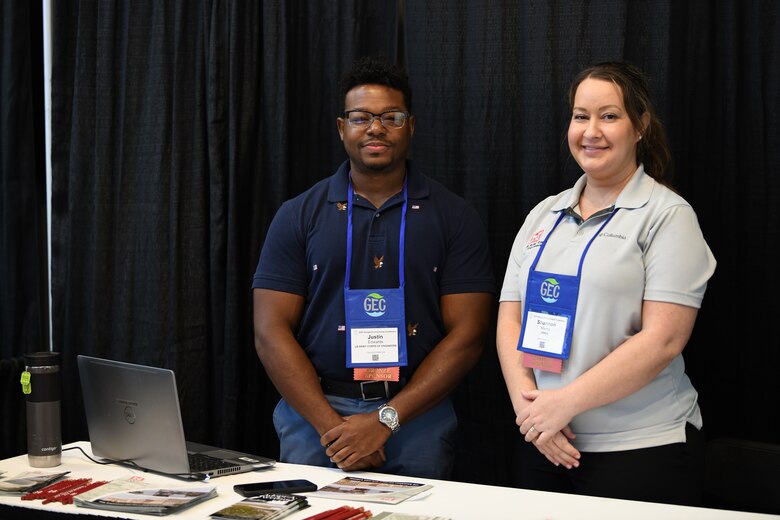 Photo of Regulatory Specialist Justin Edwards and Shannon Mardiq standing in front of a table with a laptop on it.