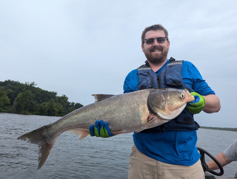 Jacksonville District's Jake Edwards pictured with invasive bighead carp during technology exchange field visit on a Mississippi River oxbow lake (July 2024).