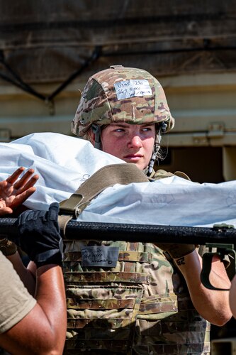 Staff Sgt. Alexis Workman hoists a simulated patient on a littler during a 4-person carry