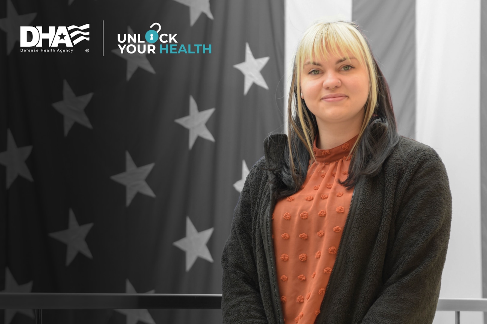 Smiling woman stands in front of American flag.