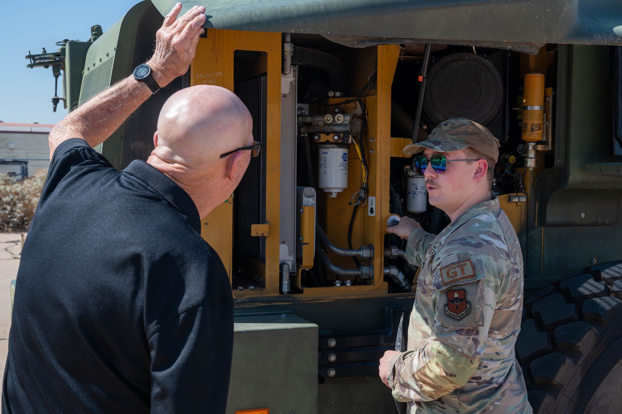 U.S. Air Force Senior Airman Gavin Parker, 56th Logistics Readiness Squadron ground transportation operator, showcases a forklift’s engine bay to retired Senior Master Sgt. Vic Peterson, community advocate, Aug. 26, 2024, at Luke Air Force Base, Arizona.