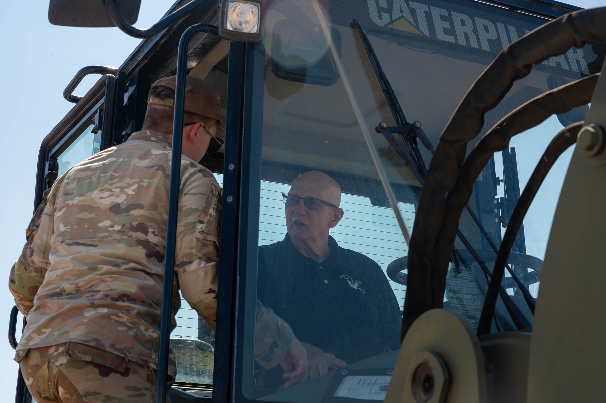 U.S. Air Force Senior Airman Gavin Parker, 56th Logistics Readiness Squadron ground transportation operator, showcases a forklift driving cab to retired Senior Master Sgt. Vic Peterson, community advocate, Aug. 26, 2024, at Luke Air Force Base, Arizona.