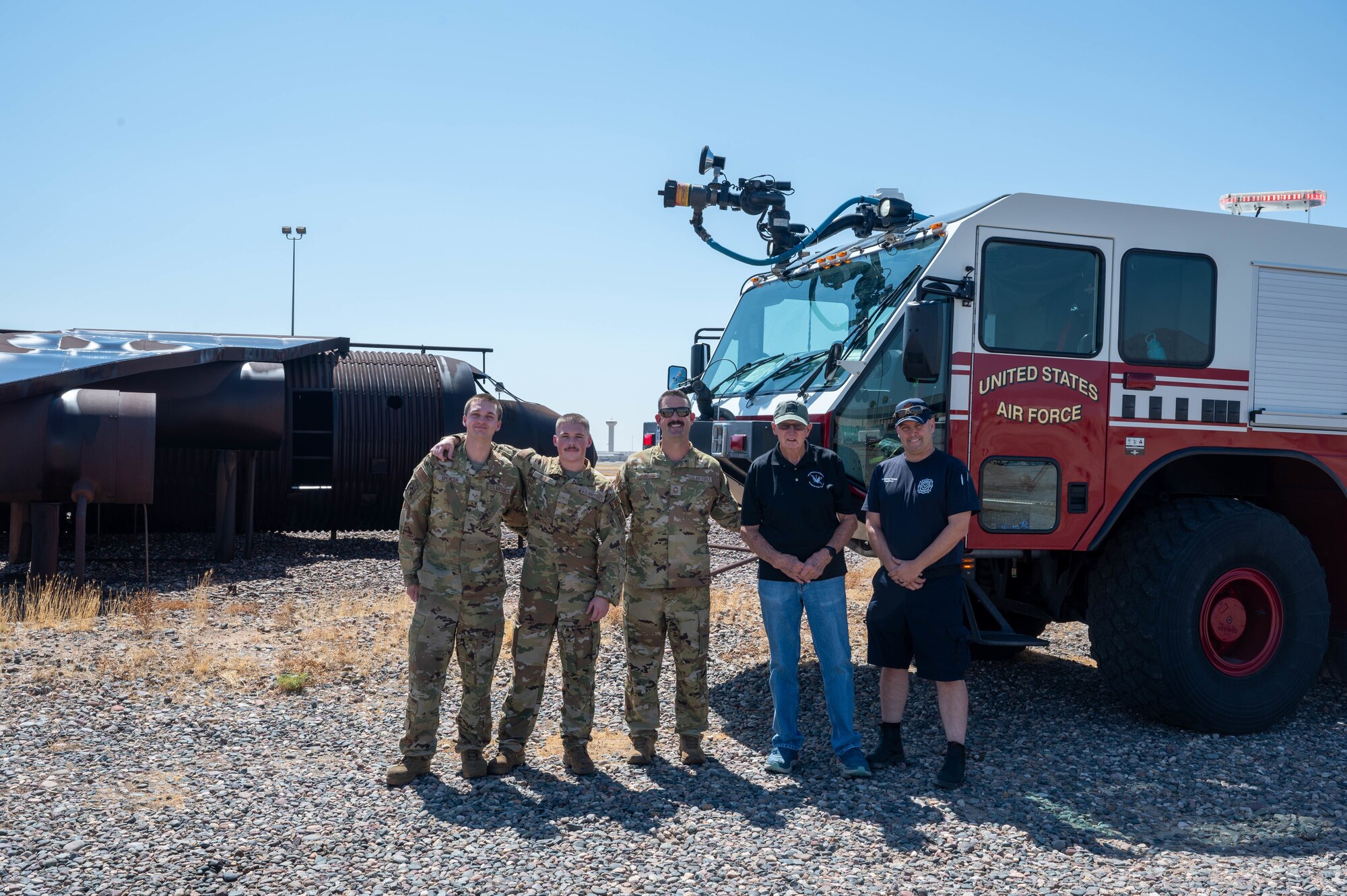 U.S. Air Force retired Senior Master Sgt. Vic Peterson (center-right,) community advocate, poses for a photo alongside Airmen assigned to the 56th Civil Engineer Squadorn fire and emergency services flight, Aug. 26, 2024, at Luke Air Force Base, Arizona.
