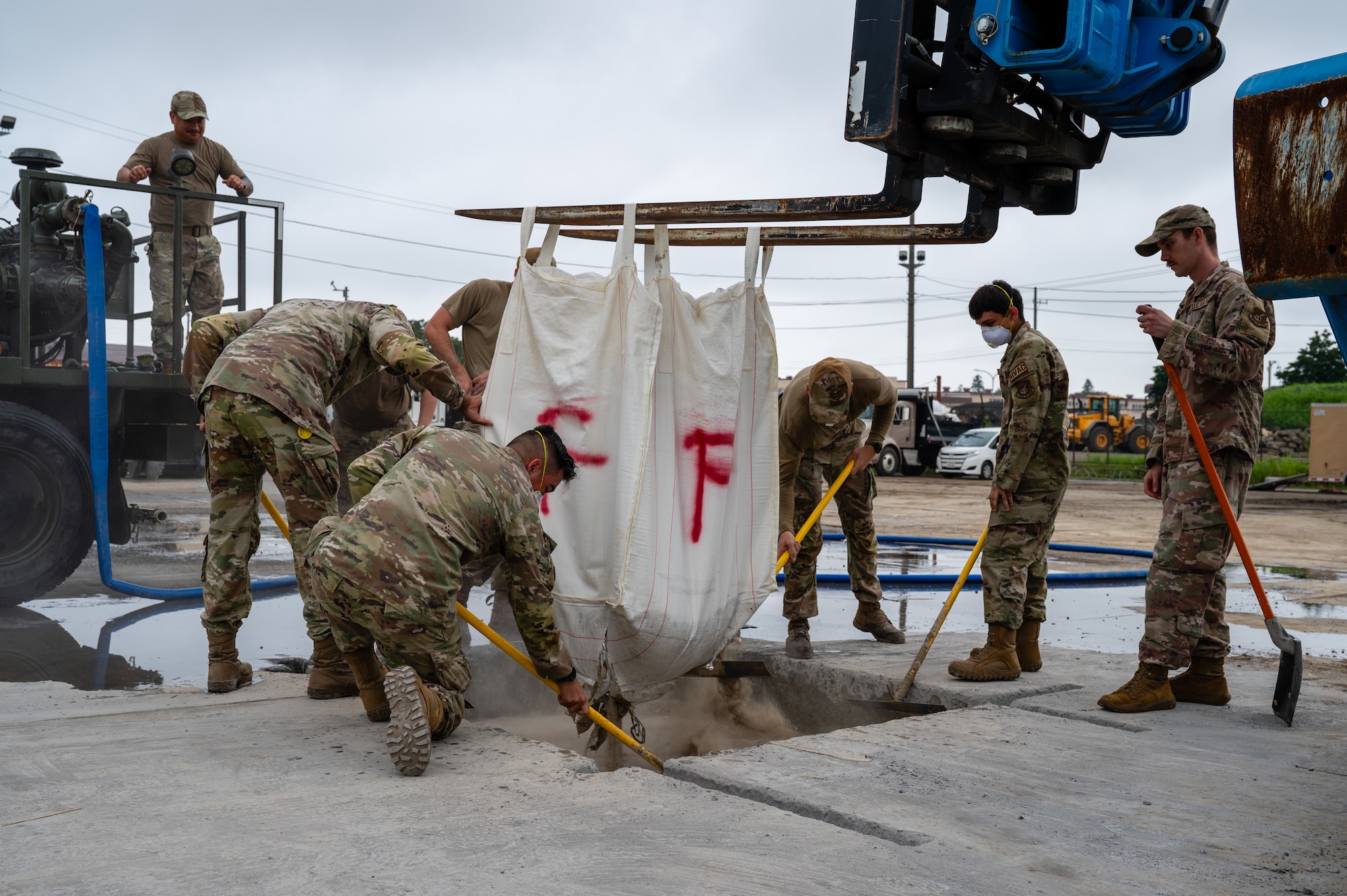 Airmen assigned to the 374th Civil Engineer Squadron pack a crater with flowable fill during a Rapid Airfield Damage Recovery exercise at Yokota Air Base, Japan.