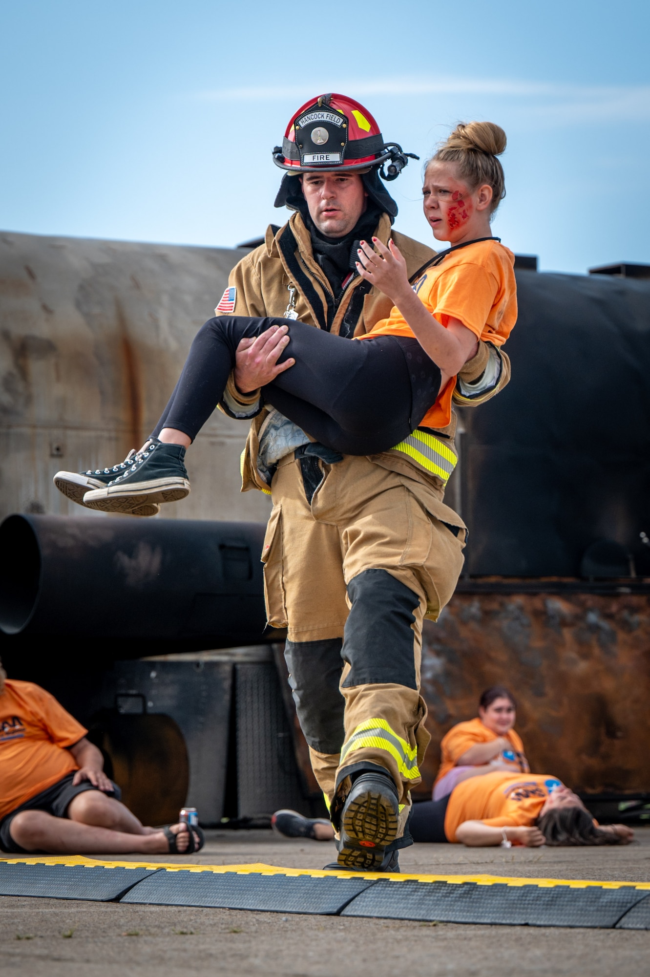 Justin Stacy, A lead firefighter assigned to the Hancock Field Air National Guard Base fire department, carries a role-player to safety while participating in a disaster drill at Syracuse Hancock International Airport, Aug. 10.
