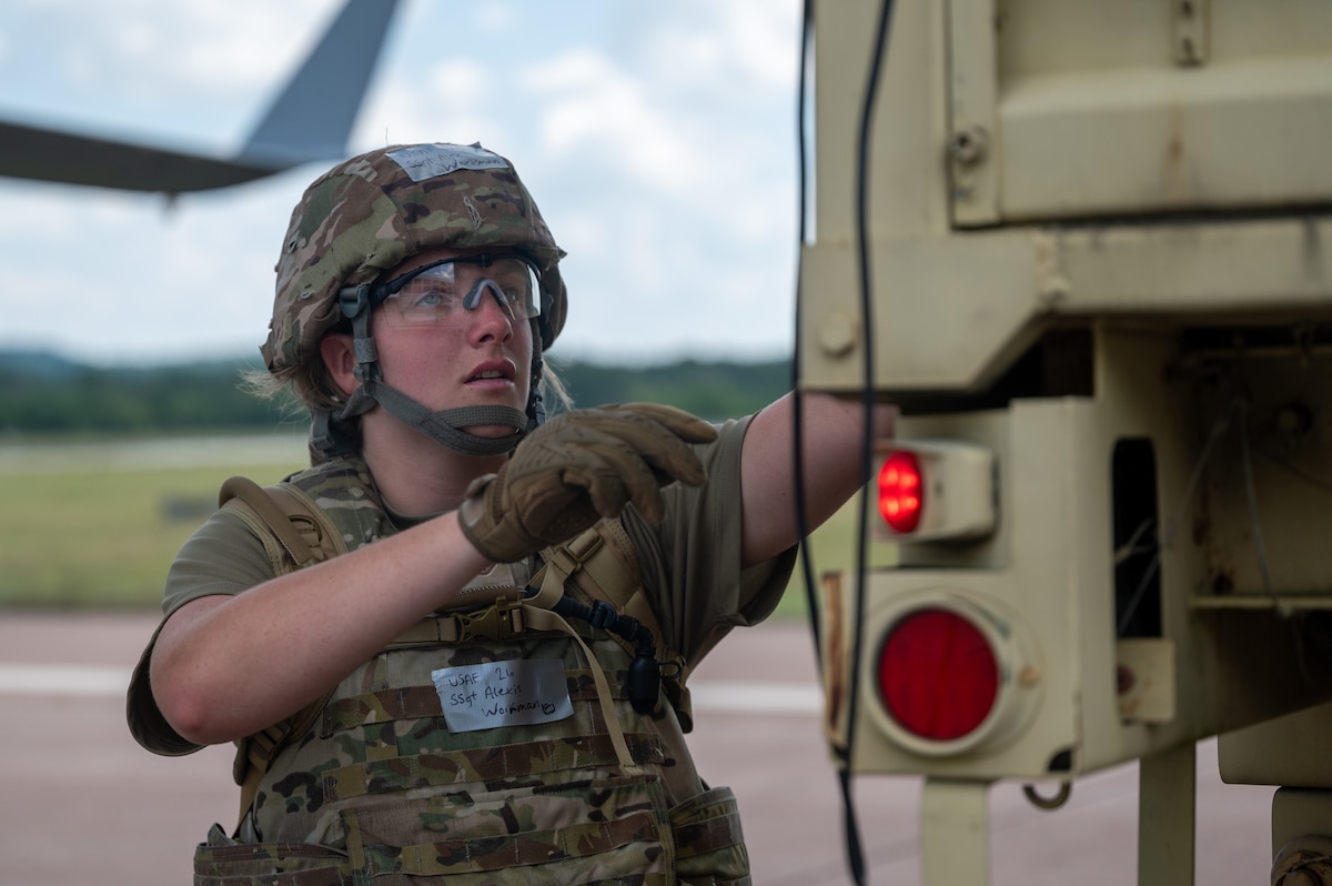 Staff Sgt. Alexis Workman opens the back of a Large Medium Tactical Vehicle containing simulated patients in preparation for patient transfer
