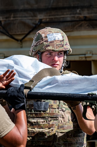 Staff Sgt. Alexis Workman hoists a simulated patient on a littler during a 4-person carry
