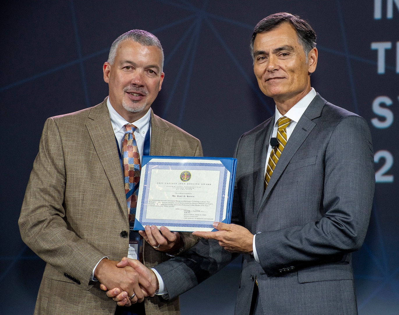 Bart D. Brown, assigned to Navy Medicine Readiness and Training Command Camp Lejeune, is presented the 2023 Capt. Joan Dooling Award “Information Professional Civilian Member of the Year” by Dr. Michael McGinnis, the executive director for U.S. Navy Bureau of Medicine and Surgery, at the 2024 Defense Health Information Technology Symposium in Dallas, Texas, Aug. 20, 2024. The Dooling Award is the ultimate recognition of professional achievement and accomplishment for deserving members of the Navy Medicine Enterprise information management and information technology community.