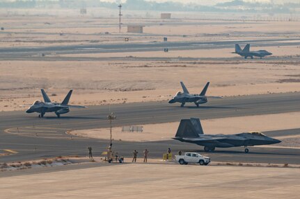 F-22 Raptors taxi after landing at an airfield in the Middle East.