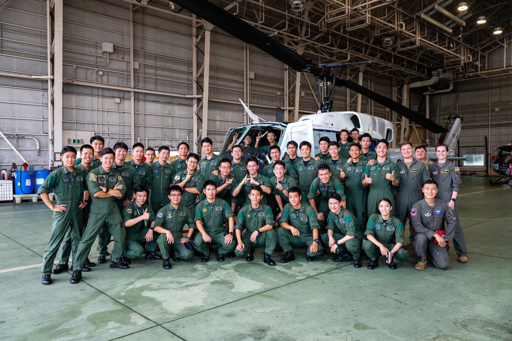 Japan Air Self-Defense Force Officer Candidate School students and members of the 374th Airlift Wing pose for a photo in front of a UH-1N Huey assigned to the 459th Airlift Squadron during a tour at Yokota Air Base, Japan.