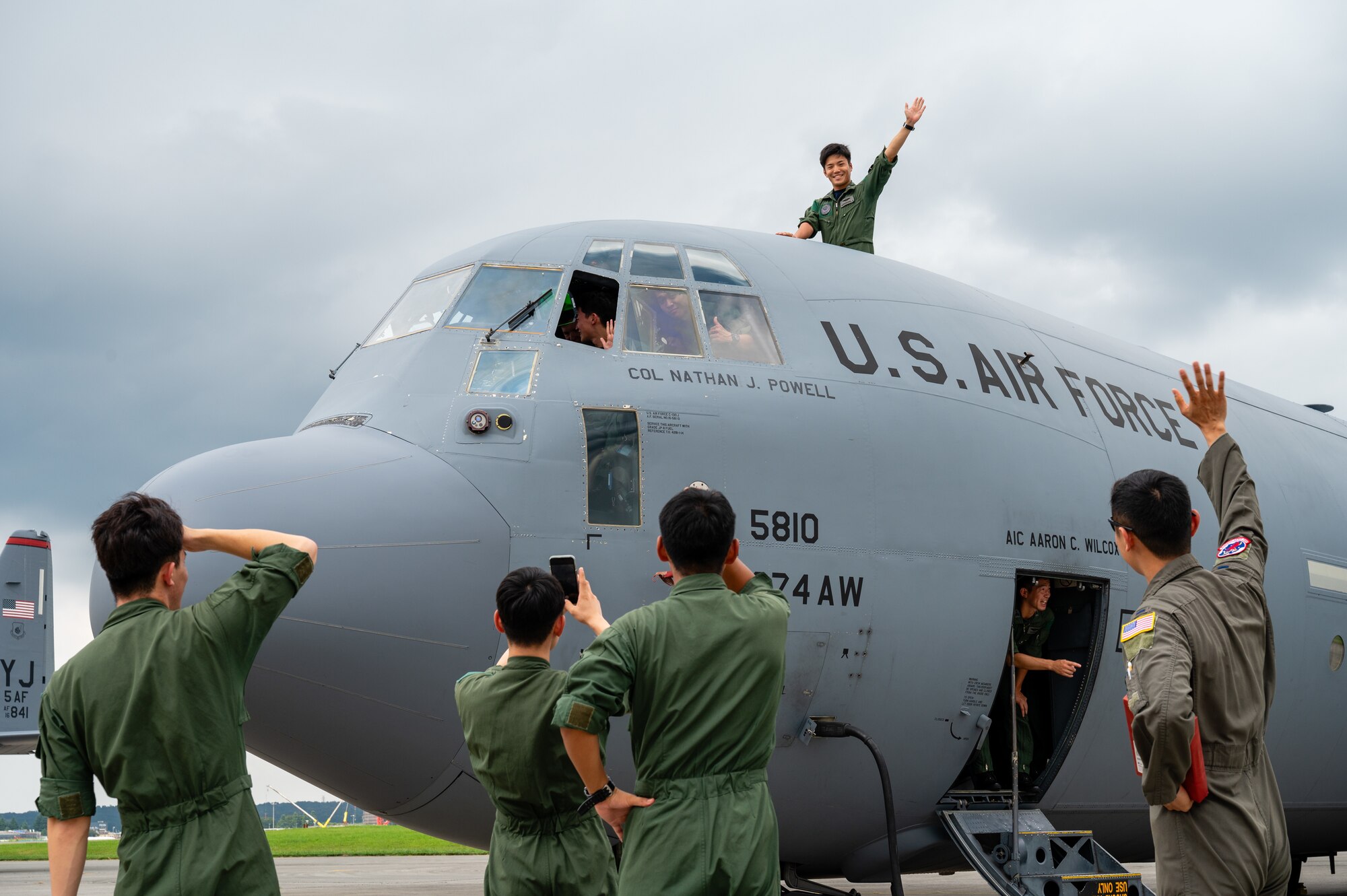 A Japan Air Self-Defense Force Officer Candidate School cadet waves from the cockpit of a C-130J Super Hercules assigned to the 36th Airlift Squadron during a tour at Yokota Air Base, Japan.