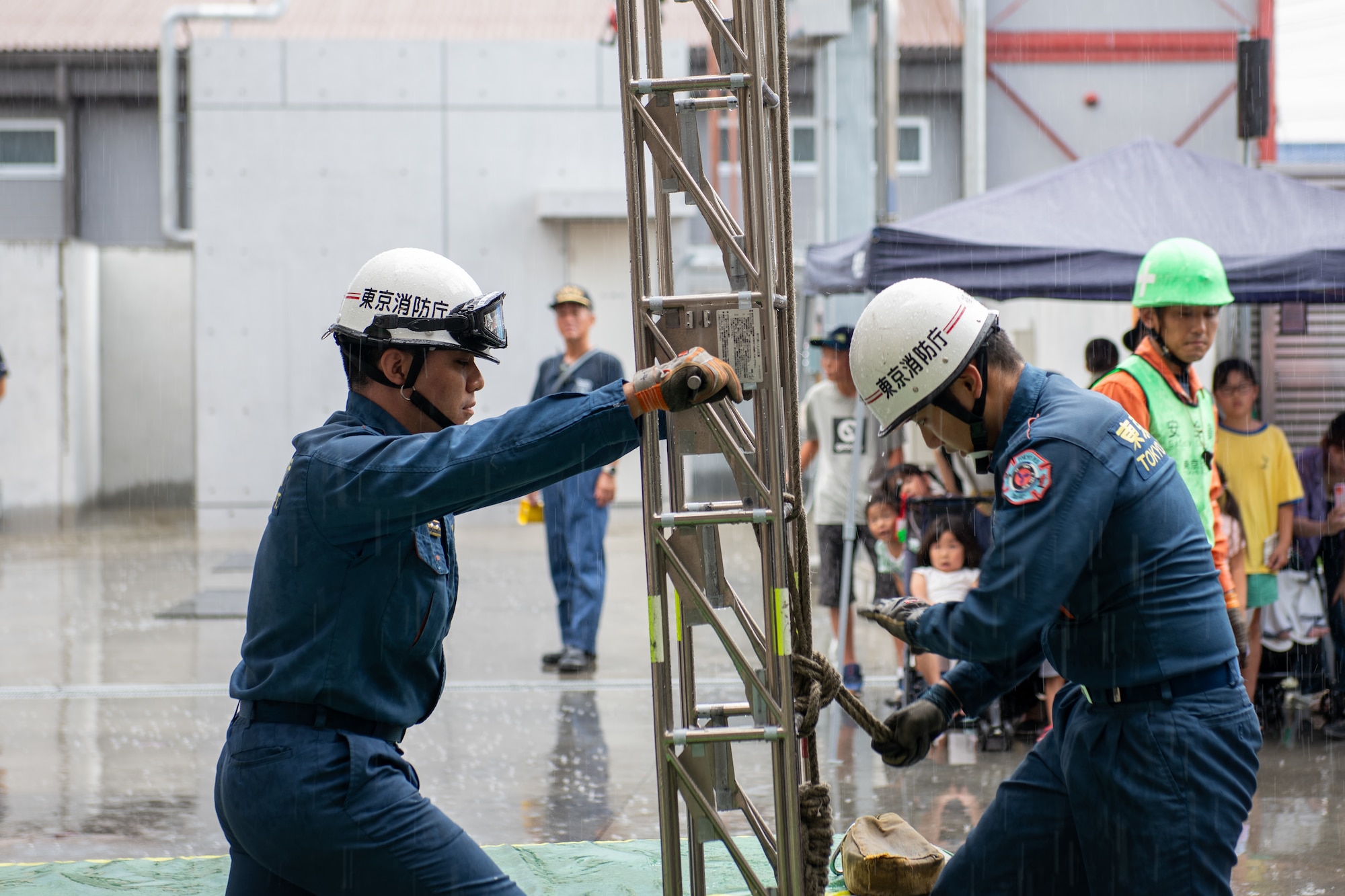 Fussa Fire Department members secure a ladder in place during a fire demonstration.