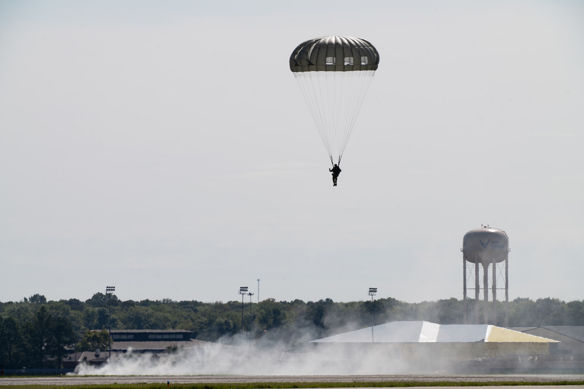 A paratrooper descends to the Robins Air Force base flight line