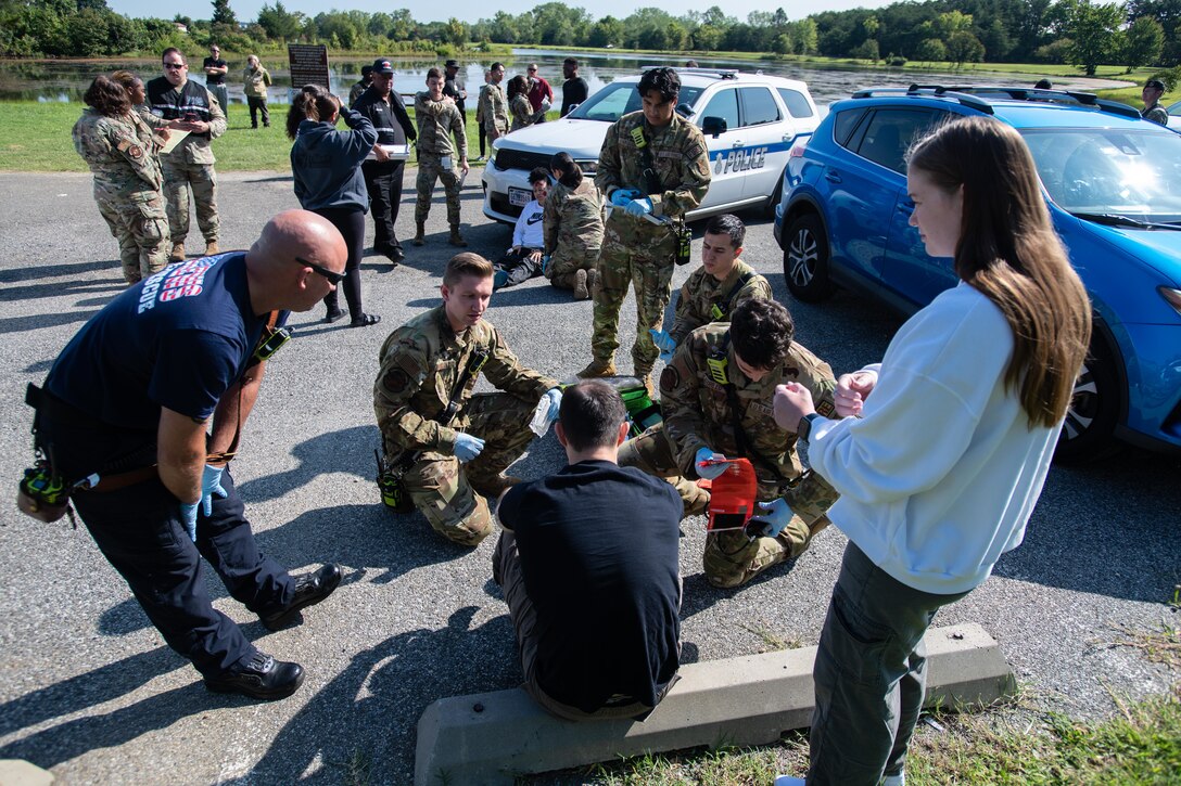 Members assigned to the 316th Medical Group check vitals of victims during a domestic violence training exercise.