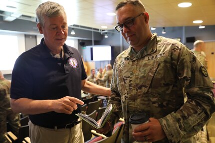 Maj. Kade Garst, 35th Infantry Division staff member, discusses the tenets of military decision-making with Ancel Nunn, a subject matter expert from the Mission Command Training Support Program, Aug. 11, 2024, at the Mission Training Complex at Fort Riley, Kansas.