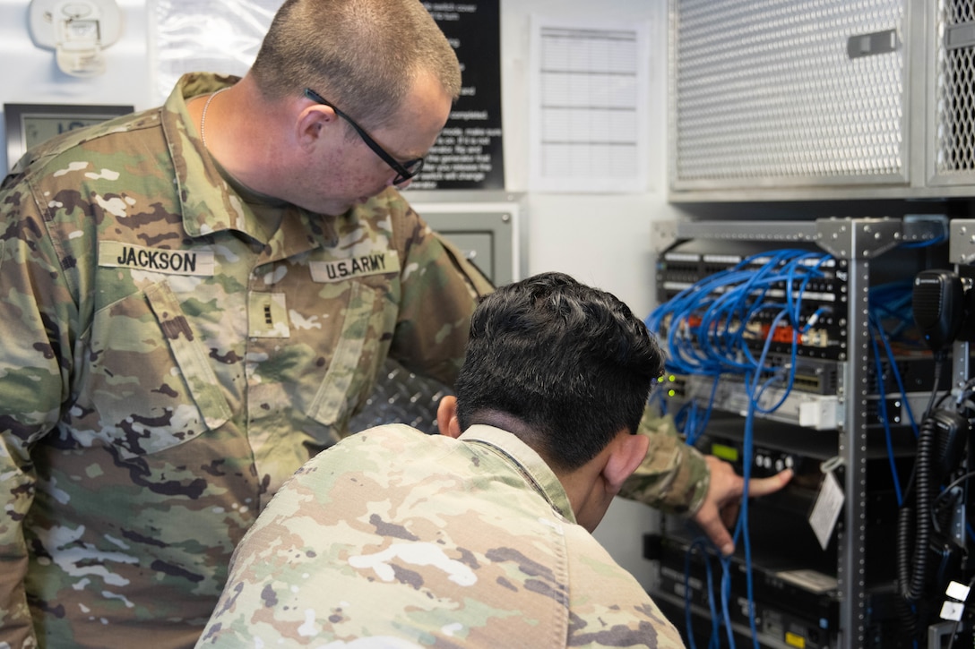 Chief Warrant Officer 3 Jeremy Jackson explains the equipment being used to Sgt. John Kutz. Soldiers from the Kentucky Army National Guard’s Communication/Information Technology Mission Command mobilized through parts of western Kentucky August 12-16 for a natural disaster response exercise. (U.S. Army National Guard Photo by Milt Spalding)