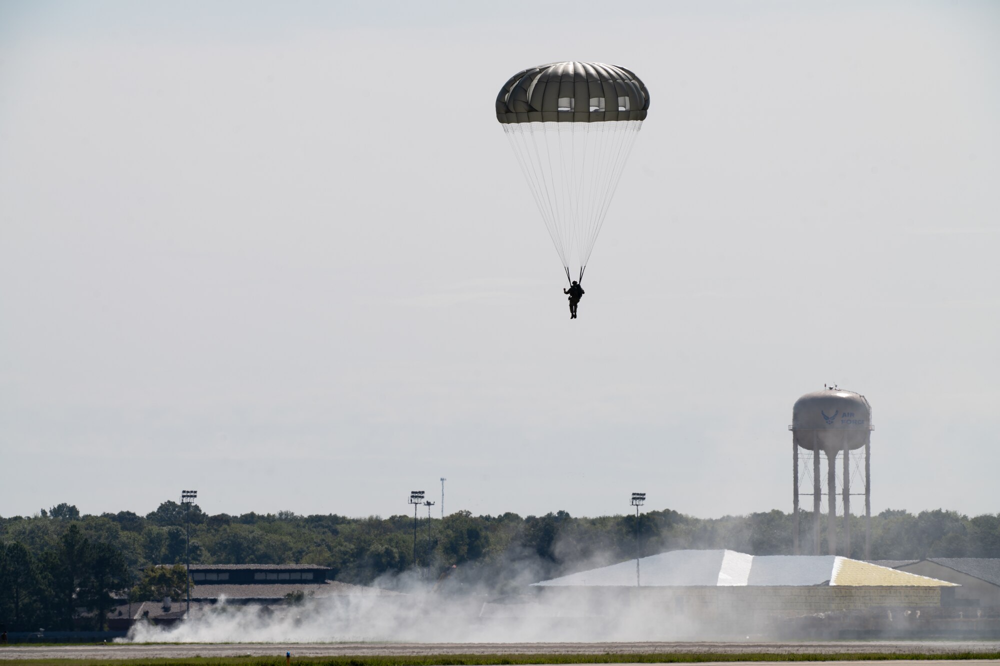 A paratrooper descends to the Robins Air Force base flight line
