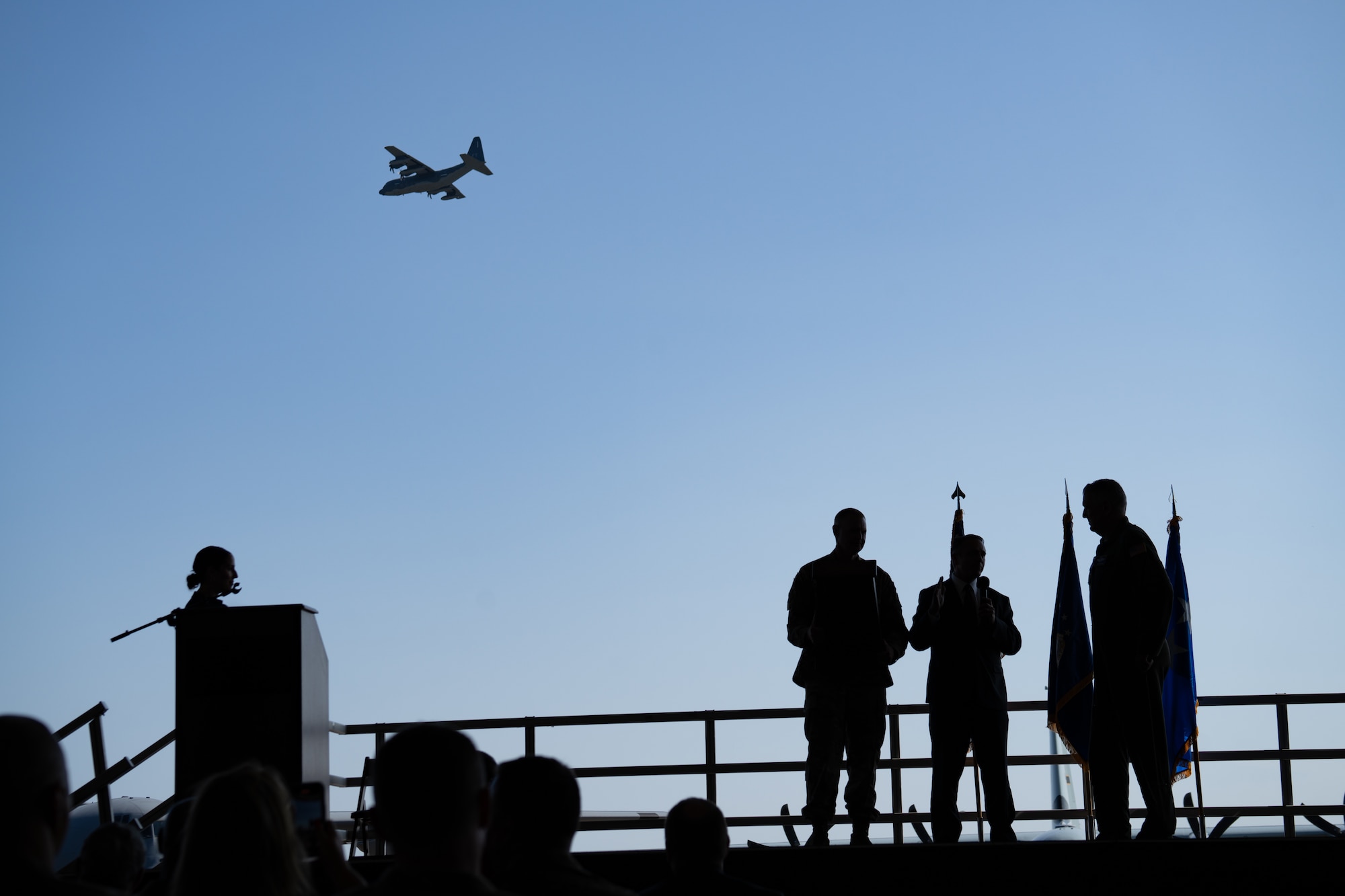 A C-130 flies over a stage