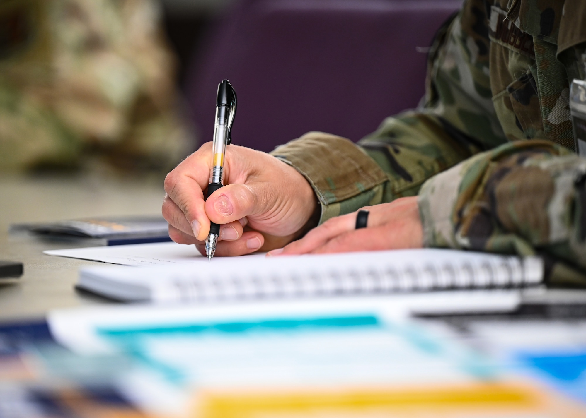 U.S. Air Force Colonel Daniel Muggelberg, Air Combat Command participant, takes notes during an Artificial Intelligence acquisition literacy course
