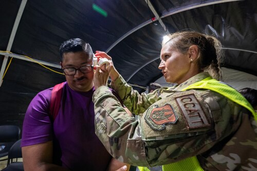 Maj. Deborah Lichota, critical care nurse for the 624th Aeromedical Staging Squadron, attends to a patient during exercise Rim of the Pacific 2024. Forty-one Citizen Airmen from the 624th ASTS participated in the 29th exercise of the biennial RIMPAC at Joint Base Pearl Harbor-Hickam, Hawaii, on July 17, 2024. During the training, the 624th ASTS members responded to a simulated mass casualty event. They treated and prepared patients in an En Route Patient Staging System for movement onto an AMBUS and C-17 aircraft. (U.S. Air Force Photo by James Bowman)