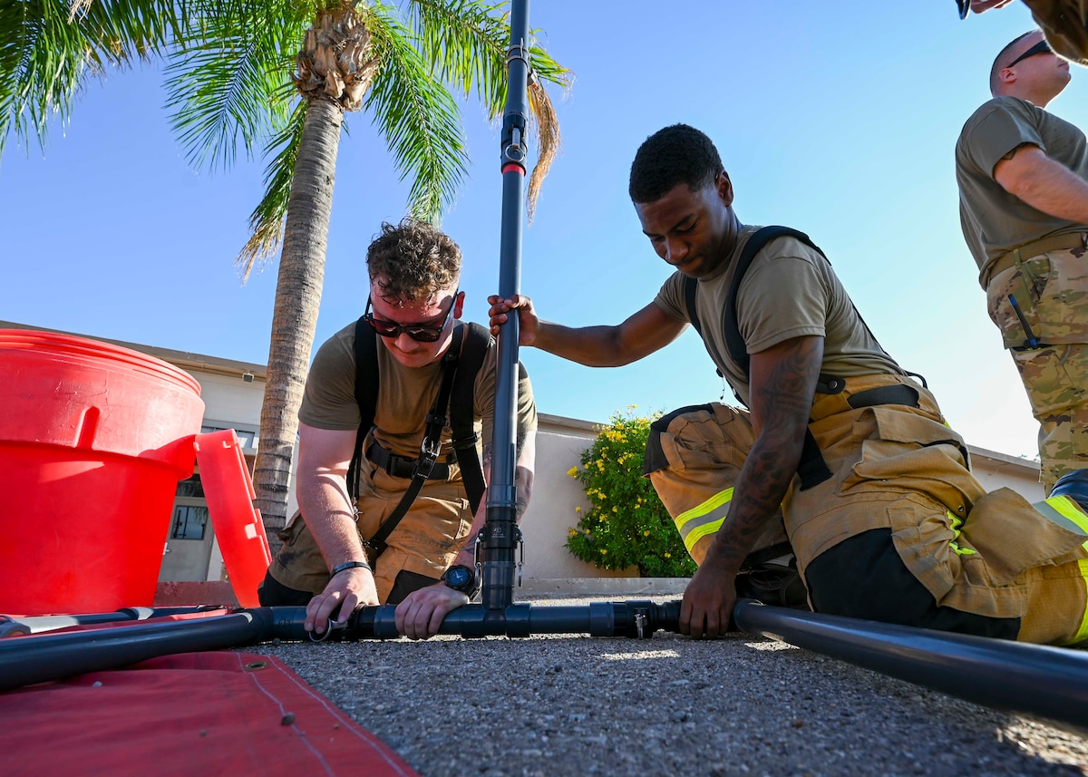 Men in firefighter uniforms set up a shower