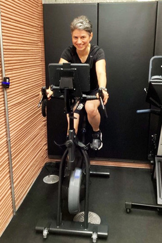 A woman pedals a stationary bicycle.