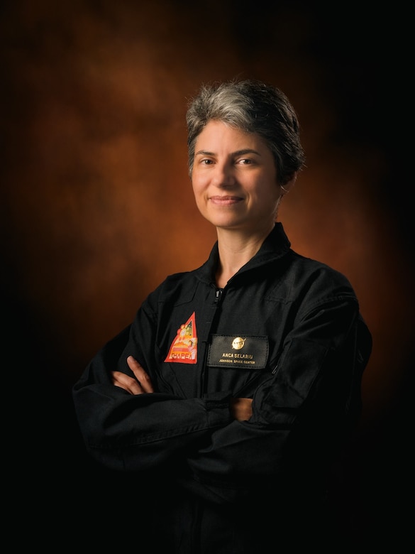 A woman with her arms crossed over her chest poses for a photo.