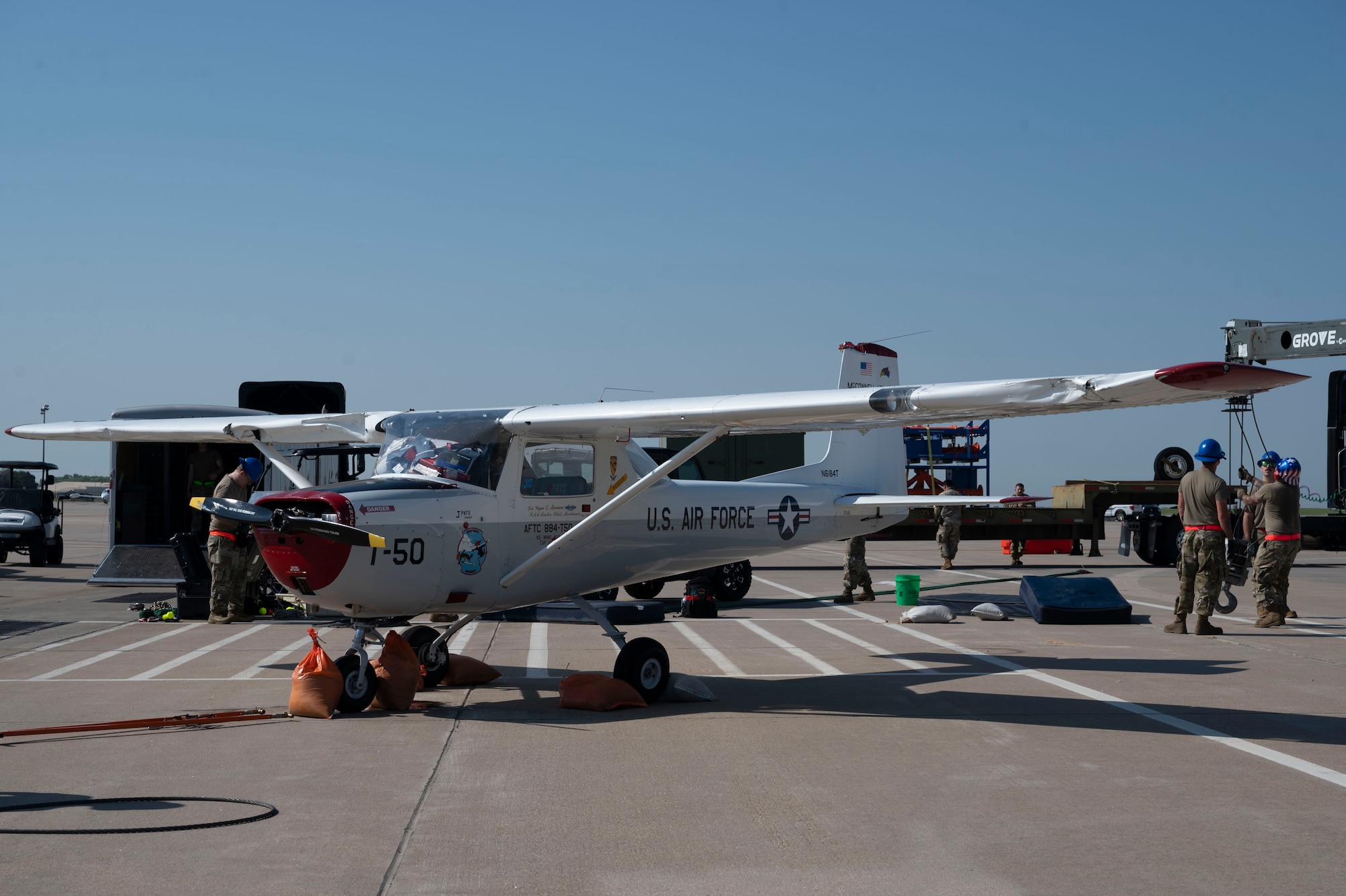 A Cessna 150 is righted by the 22nd Aircraft Maintenance Squadron Crash Damage or Disabled Aircraft Recovery team Aug. 26, 2024, at McConnell Air Force Base, Kansas. The aircraft was flipped during a thunderstorm with wind gusts of up to 54 mph on Aug. 25, 2024. The storm caused damage to several visiting aircraft and vendor stands leading to the cancelation of the second day of the Frontiers in Flight Airshow. The CDDAR team used airbags, forklifts and cranes to raise, pull and flip the aircraft back on its wheels. (U.S. Air Force photo by Airman 1st Class Gavin Hameed)