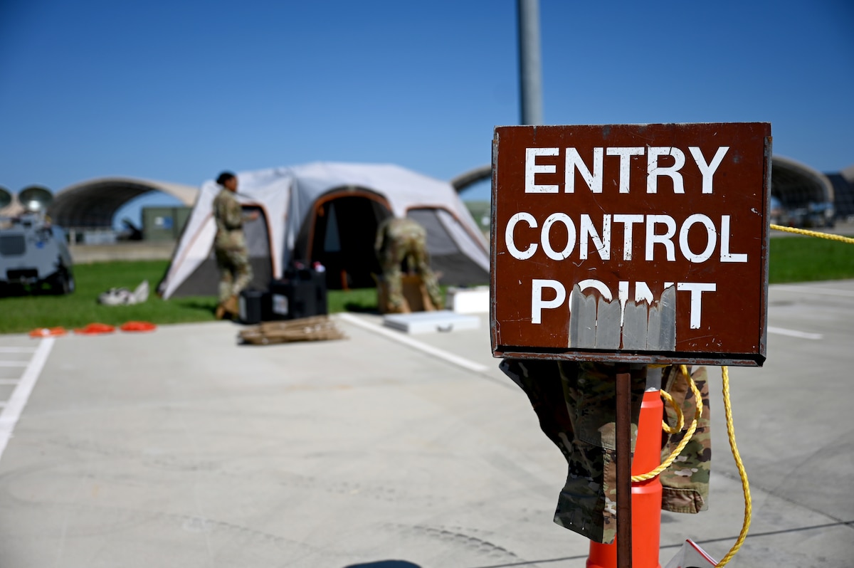Two Airmen disassemble a tent and the equipment inside