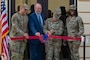 Col. Michael Maginness, 2nd Bomb Wing commander, Eric Barkley, President of Barksdale Forward, Lt. Col. Jennifer Jones, 2nd Communications Squadron commander, and Chief Master Sgt. Sylvetris Hlongwane, 2nd BW command chief, partake in the cutting of the ribbon at the ribbon-cutting ceremony for the new 2nd Communications Squadron consolidated facility at Barksdale Air Force Base, Aug. 28, 2024. Ribbon cuttings are ceremonies that inaugurate the opening of a new building or business. (U.S. Air Force photo by Airman 1st Class Aaron Hill)