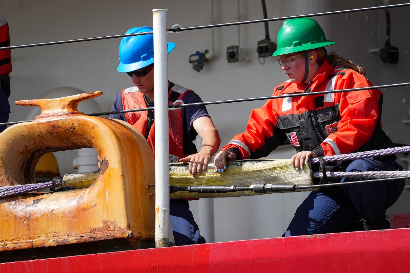 Crew members from U.S. Coast Guard Cutter Polar Star (WAGB 10) apply chafing gear to one of the lines after the cutter arrived at its homeport of Coast Guard Base Seattle, Aug. 25, 2024. The Polar Star is the only active heavy-duty icebreaker in the Coast Guard's fleet. (U.S. Coast Guard photo by Petty Officer 2nd Class Steve Strohmaier)