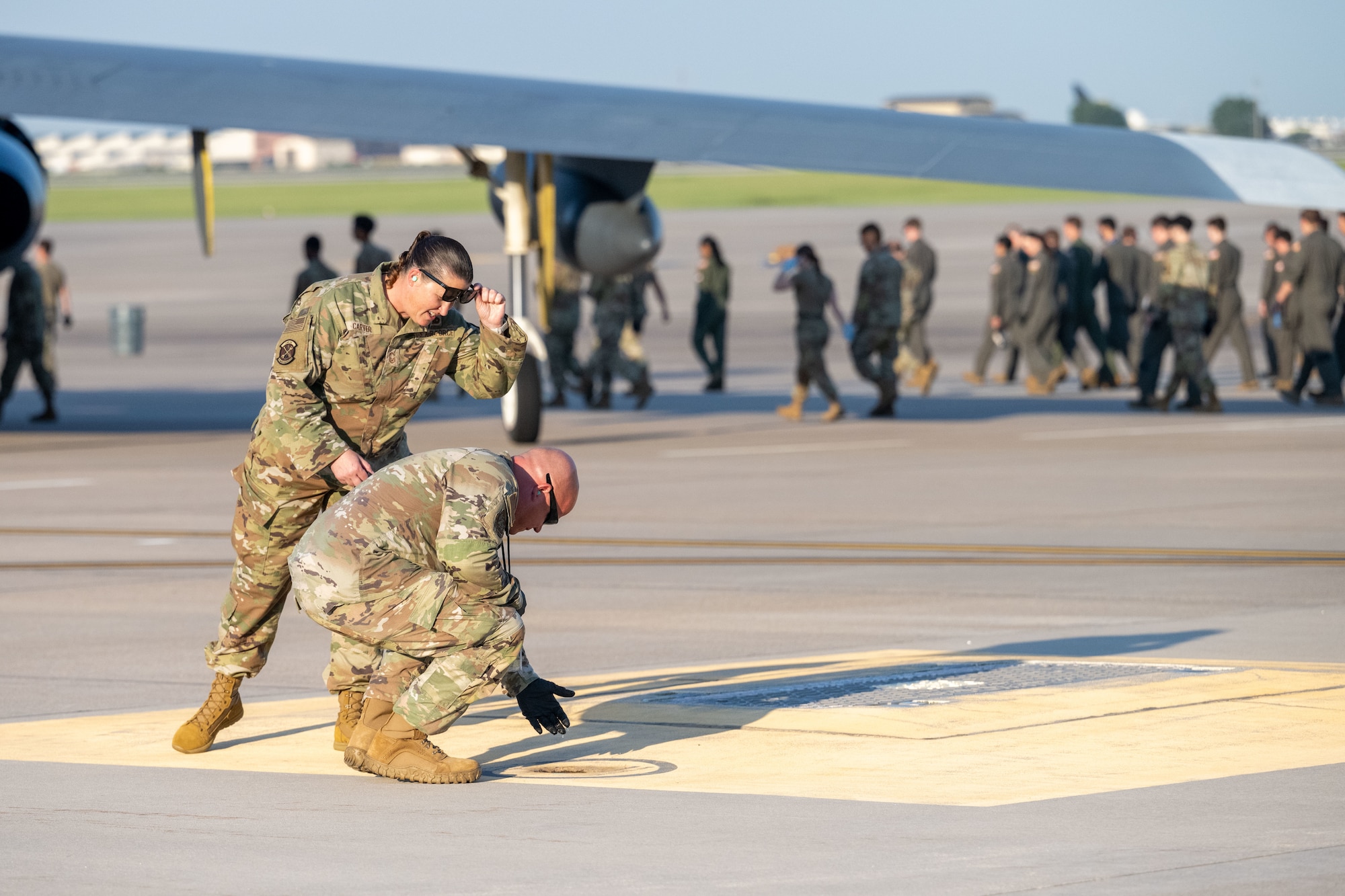Senior Master Sgt. Deanna Carter, 22nd Maintenance Squadron fabrication flight chief, cleans up during a foreign object debris (FOD) walk following the Frontiers in Flight Air Show Aug. 26, 2024, at McConnell Air Force Base, Kansas. FOD included materials such as rocks, loose hardware, and litter from the air show. (U.S. Air Force photo by Airman 1st Class Paula Arce)