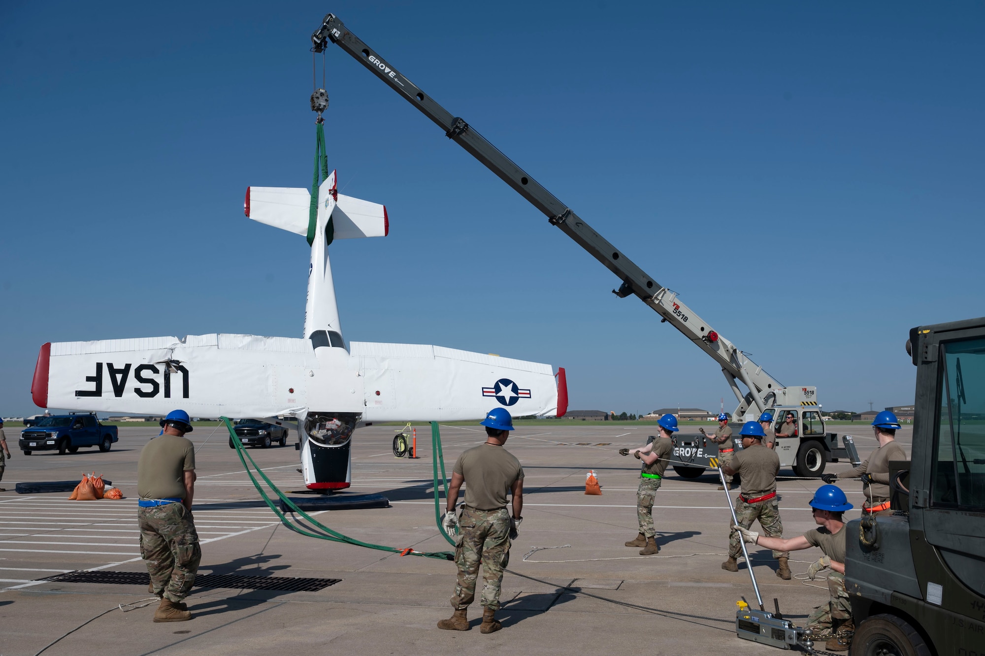 Airmen from the 22nd Aircraft Maintenance Squadron Crash Damage or Disabled Aircraft Recovery team used airbags, forklifts and cranes to raise, pull and stabilize a flipped aircraft Aug. 26, 2024, at McConnell Air Force Base, Kansas. The aircraft was flipped during a thunderstorm with wind gusts of up to 54 mph Aug. 25, 2024. The storm caused damage to several visiting aircraft and vendor stands leading to the cancelation of the second day of the Frontiers in Flight Airshow. (U.S. Air Force photo by Airman 1st Class Gavin Hameed)