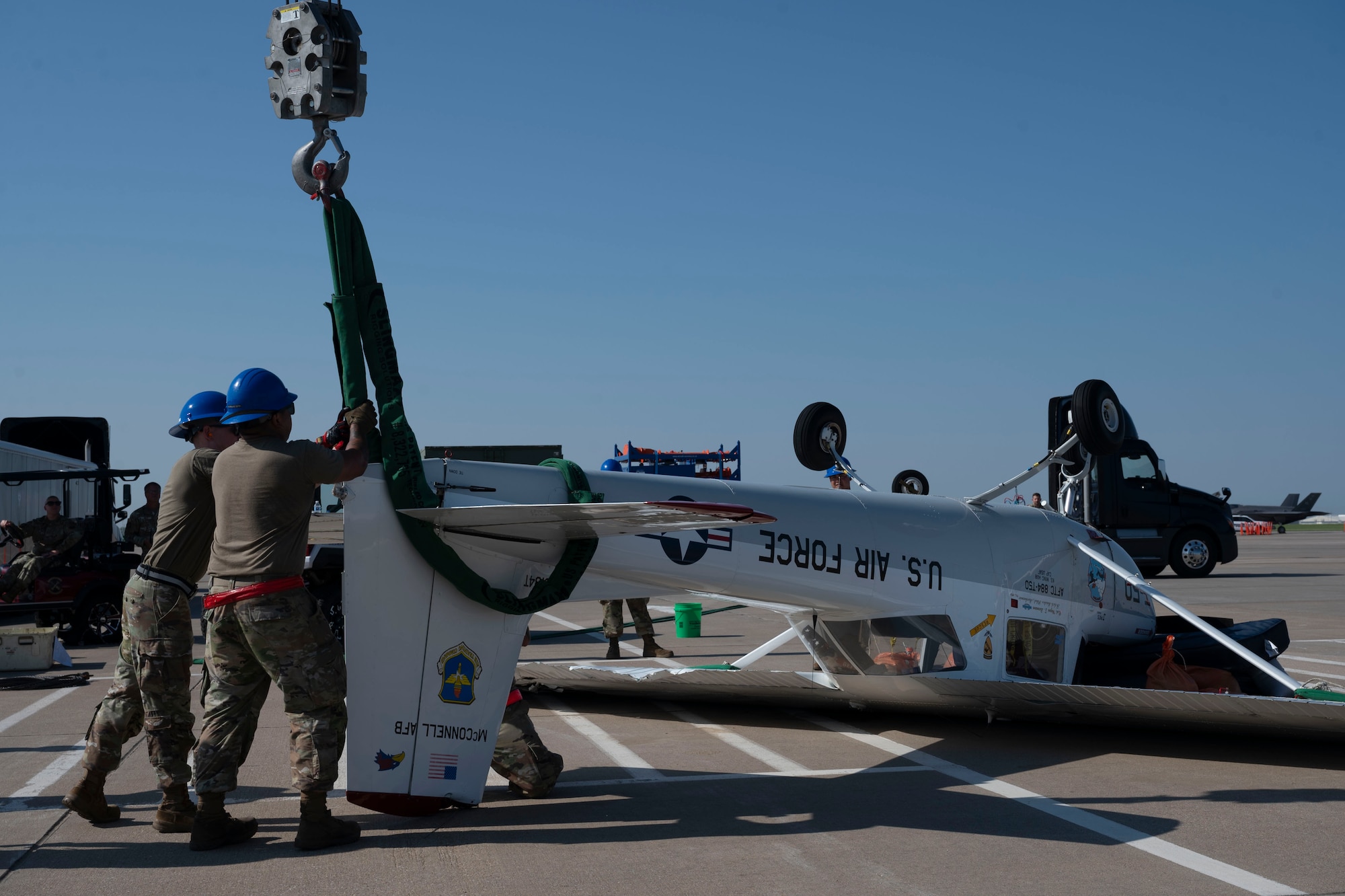 Airmen from the 22nd Aircraft Maintenance Squadron Crash Damage or Disabled Aircraft Recovery team hoist up a flipped aircraft with airbags and a crane lift Aug. 26, 2024, at McConnell Air Force Base, Kansas. The aircraft was flipped during a thunderstorm with wind gusts of up to 54 mph Aug. 25, 2024. The storm caused damage to several visiting aircraft and vendor stands leading to the cancelation of the second day of the Frontiers in Flight Airshow. (U.S. Air Force photo by Airman 1st Class Gavin Hameed)