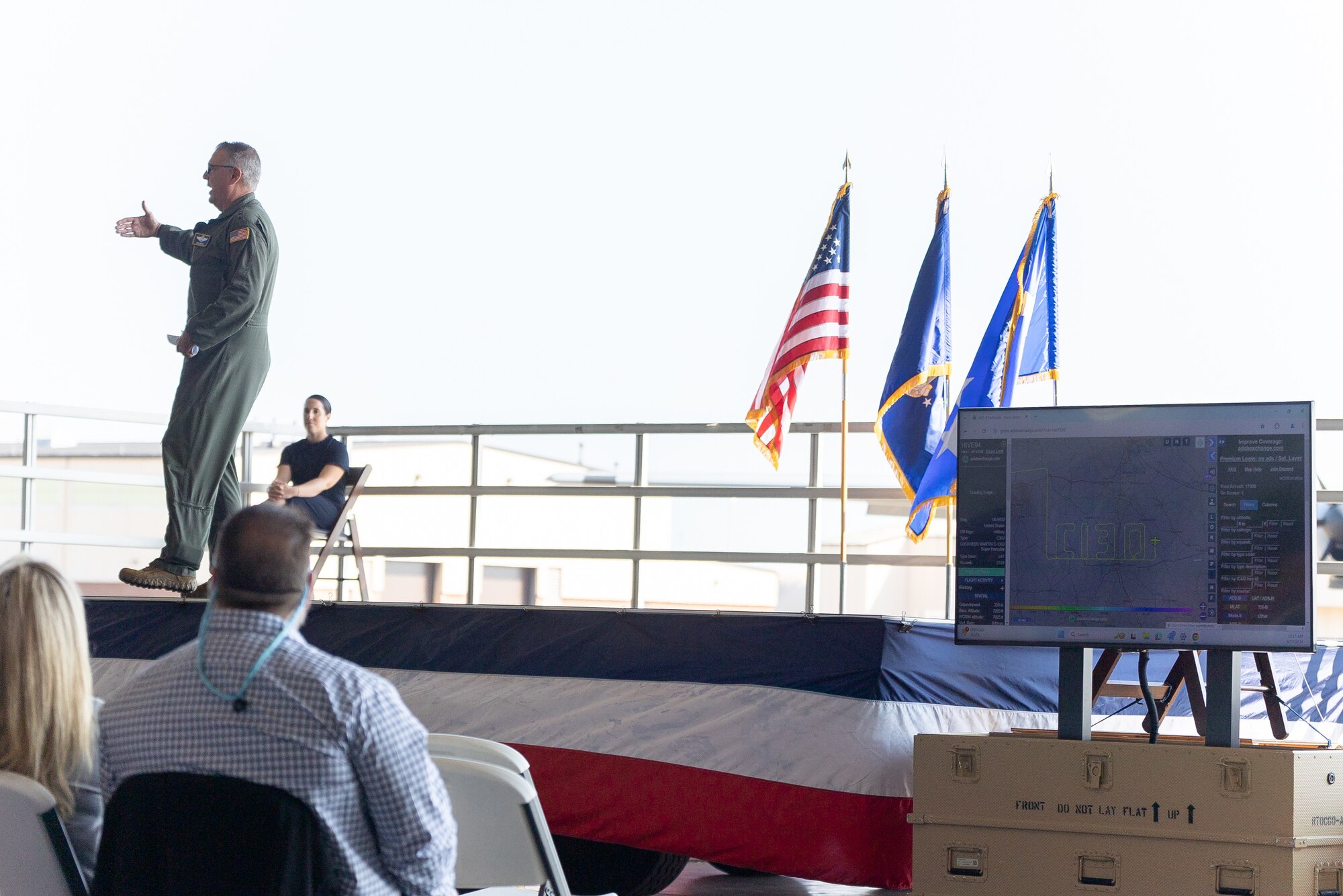 Gen. Mike Minihan delivers keynote remarks while a C-130 traces "C130" midair Aug. 23, 2024 at Robins Air Force Base, Georgia. Minihan, Commander Air Mobility Command, spoke at the 70th anniversary celebration for the C-130 attended by Air Force and Lockheed Martin leaders. (U.S. Air Force photo by Chris Bishop)