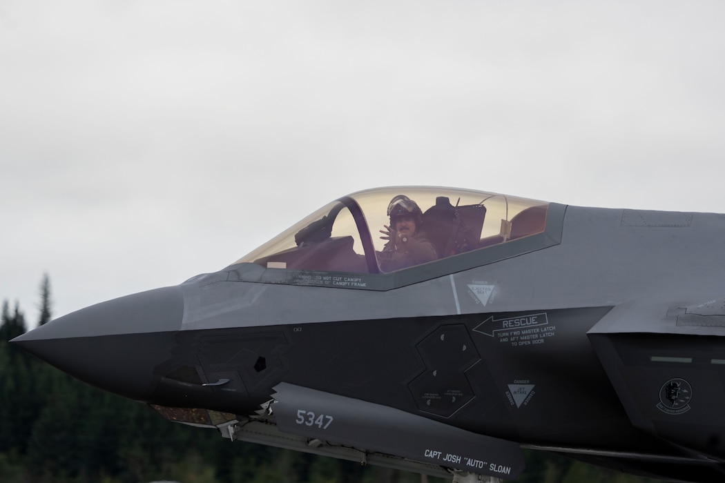 A U.S. Air Force F-35 Lightning II pilot, assigned to the 356th Fighter Squadron, gives the “Green Demons” hand sign while taxiing