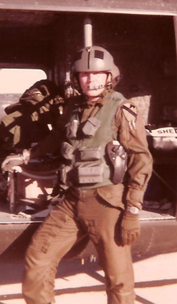 Chief Warrant Officer Charles Carlos Cantu, an aviator with 3rd Battalion 25th Aviation Regiment, 25th Combat Aviation Brigade, stands outside a UH-1 Huey helicopter during the earlier part of his career as an Army Aviator. Cantu retired Aug. 5 at Contingency Operating Base Speicher after piloting his final flight on a CH-47 Chinook.