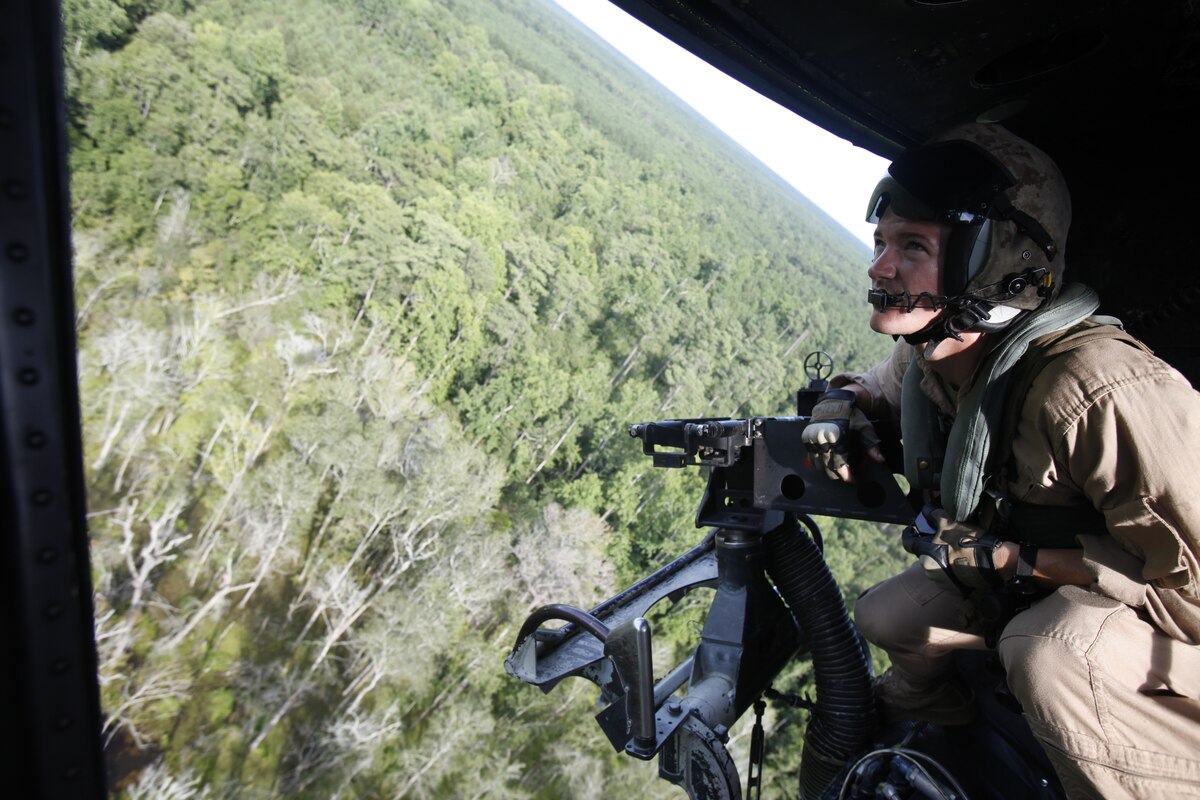 Lance Cpl. Mitchell M. W. Moss, a crew chief with Marine Light Attack helicopter Squadron 467, strains his eyes for any sign of the enemy near Camp Devil Dog, N.C., Aug. 9. Two UH-1N Huey helicopters provided simulated close air support for a platoon of infantry in an urban terrain training town.